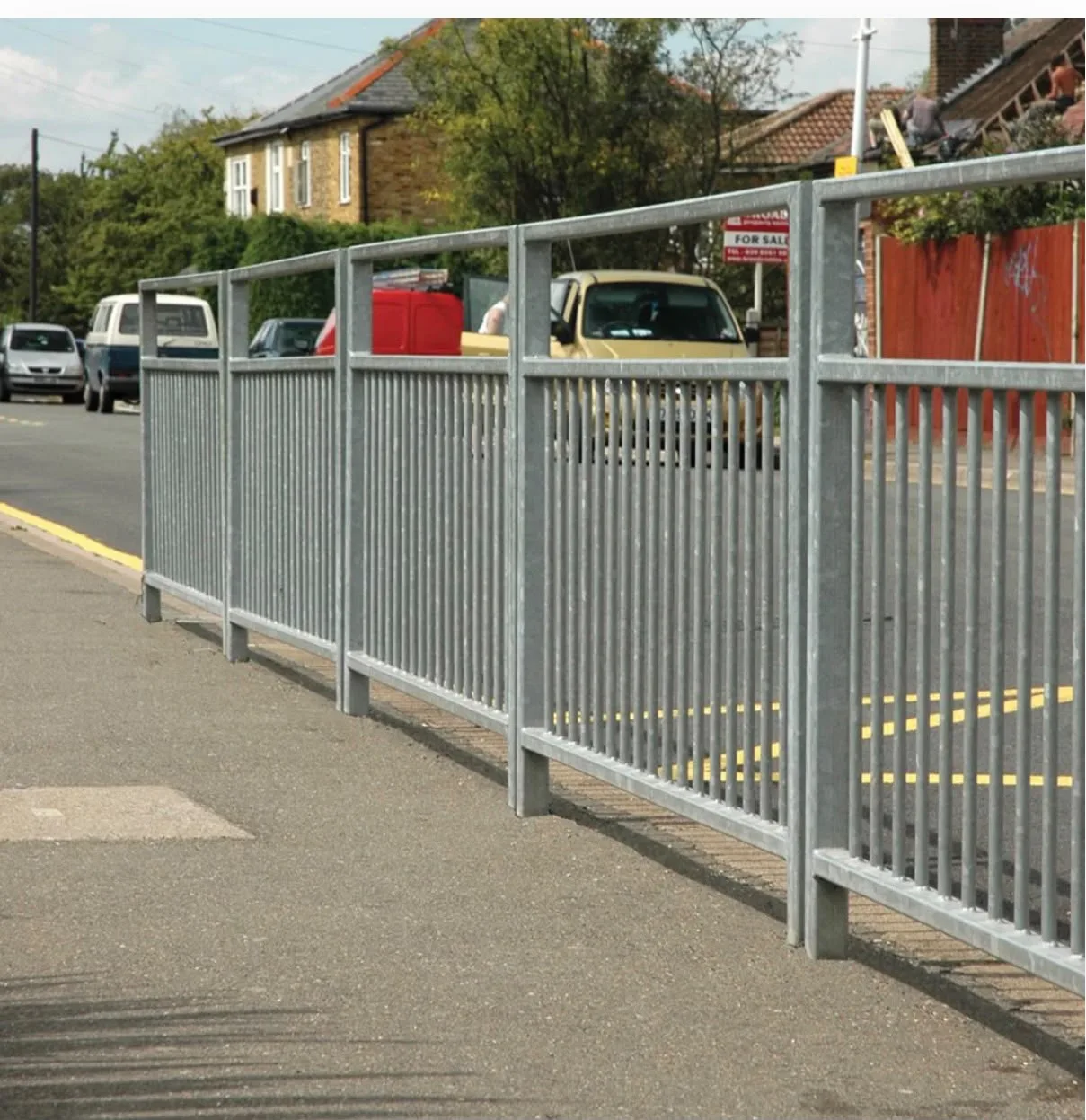 Galvanised pedestrian guardrail along the edge of a pavement