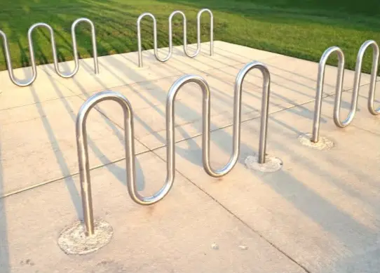 Stainless steel wave cycle racks on a concrete plaza