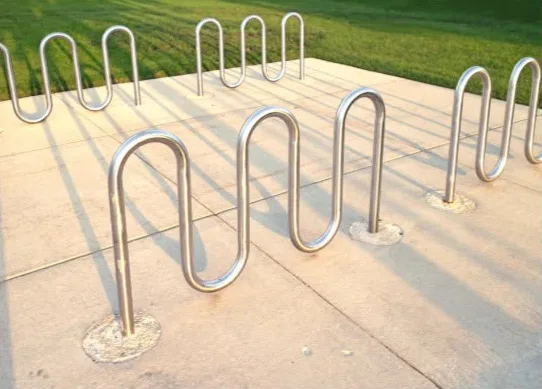 Stainless steel wave cycle racks on a concrete plaza